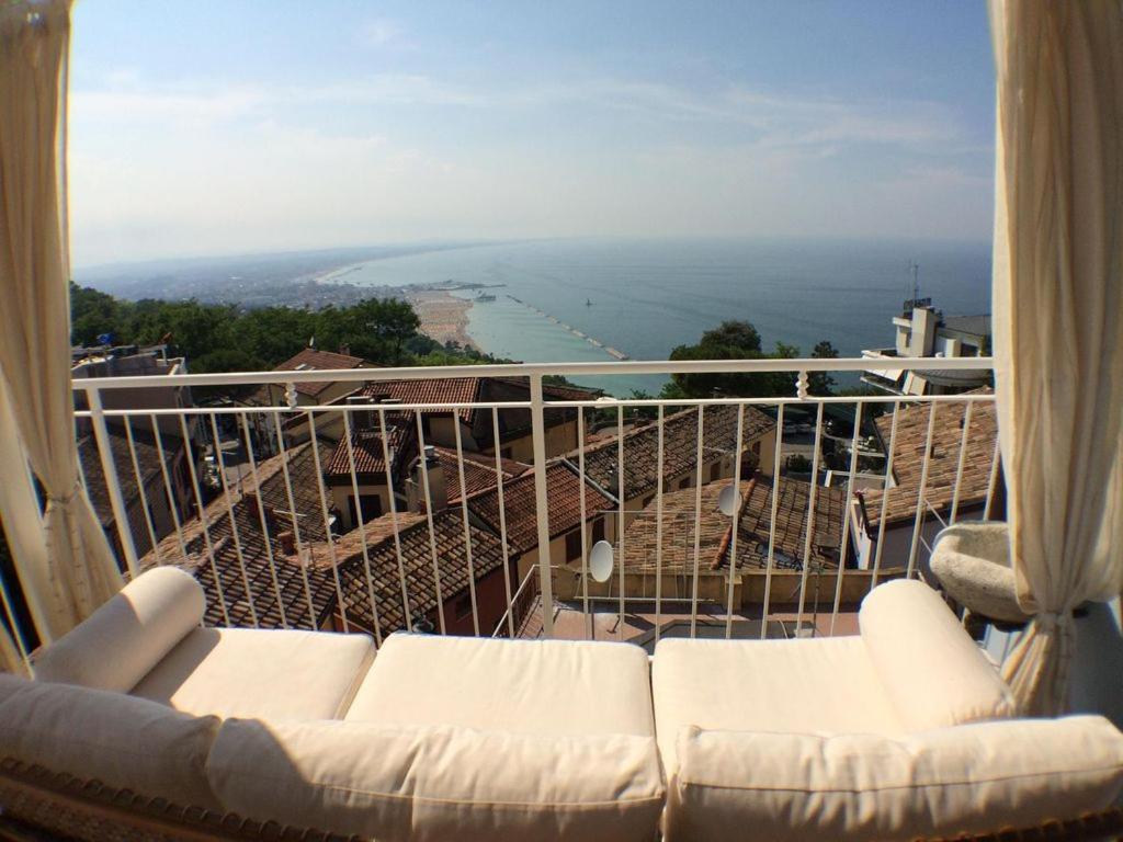 a couch sitting on a balcony with a view of the ocean at Casa Nina in Gabicce Mare