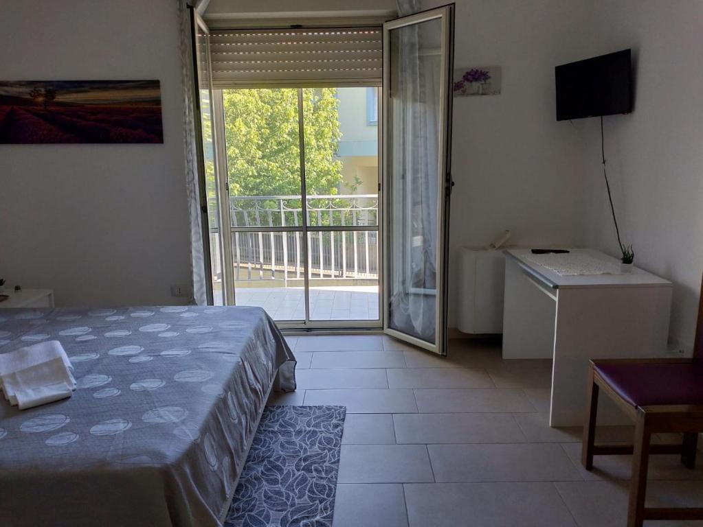 a bedroom with a bed and a view of a balcony at La Santera in Marina di Davoli