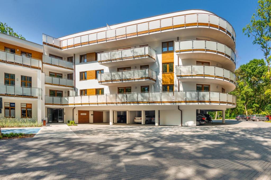 un immeuble d'appartements avec un grand parking dans l'établissement Apartamenty Cypel Helski, à Hel