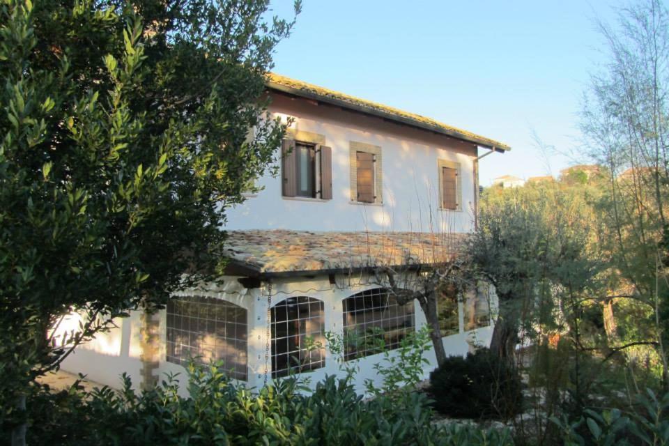 une maison blanche avec des arbres devant elle dans l'établissement Il Melograno, à Torino di Sangro
