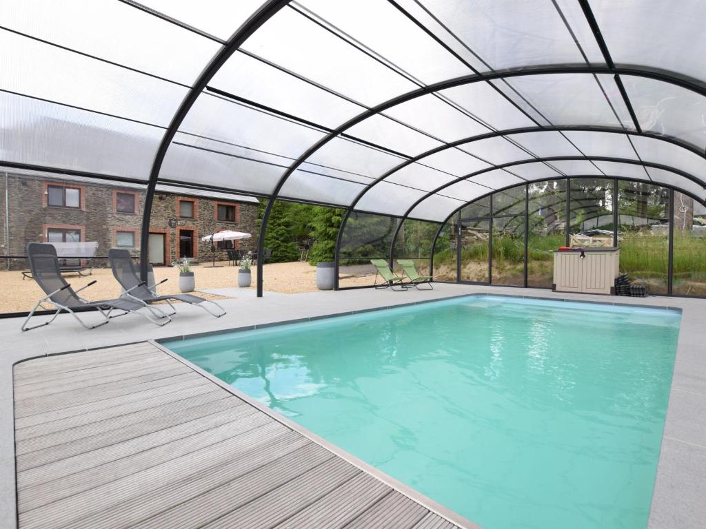 a swimming pool with a retractable canopy over it at Country house in the Ardennes with Schwimmbad in Warempage