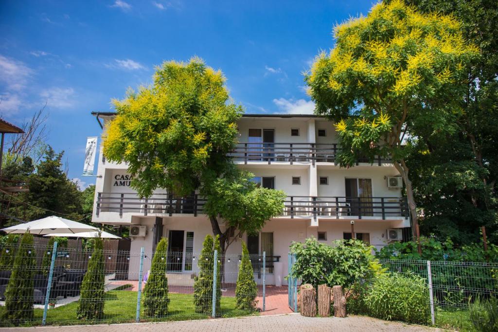 un edificio bianco con un albero di fronte di Casa Amur a Jupiter