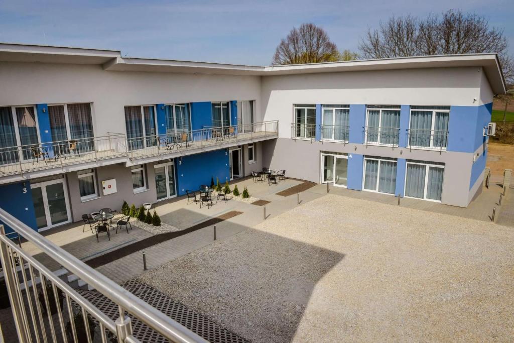 - une vue extérieure sur un bâtiment avec des tables et des chaises dans l'établissement Penzión Fonte, à Radava