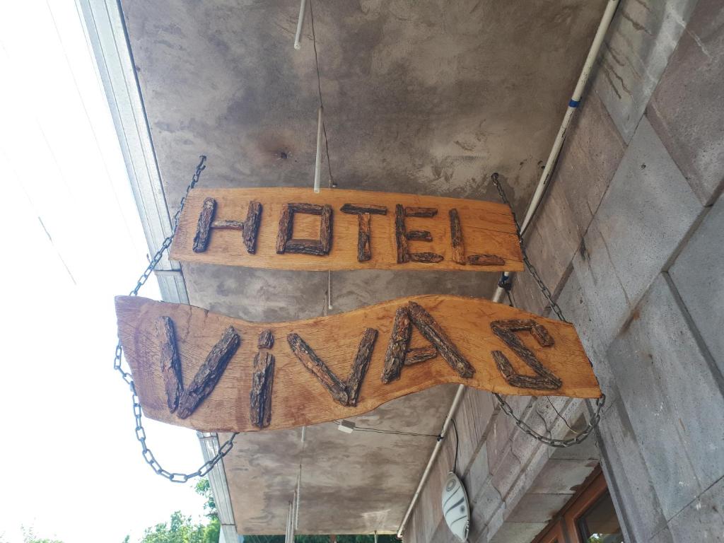 una señal que dice hellowan colgando de un edificio en Hotel VIVAS, en Goris
