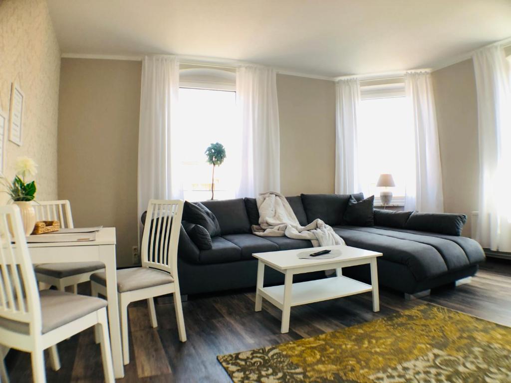 - un salon avec un canapé, une table et des chaises dans l'établissement Hafencity Apartments, à Tönning