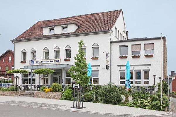 a white building with blue umbrellas in front of it at Bayrischer Hof in Melle