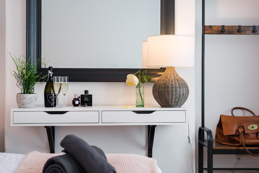 a white dressing table with a lamp and a mirror at Nomi Homes - Exeter - BOOKDIRECT - Central - BEACH - WIFI in Exeter
