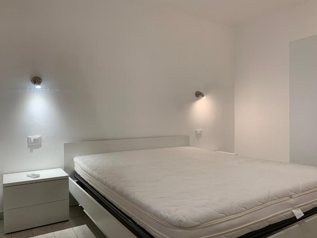 Posto letto in camera con parete bianca di Trilocale Porto Azzurro a Porto Azzurro
