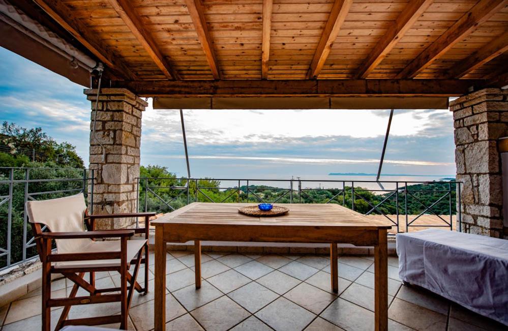 a wooden table and a chair on a patio at Ionian Seaview apartments in Syvota