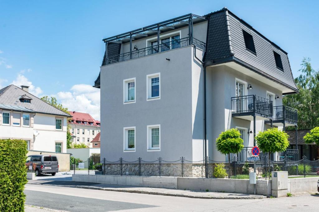 una casa blanca con techo negro en Apart of me Villach, en Villach