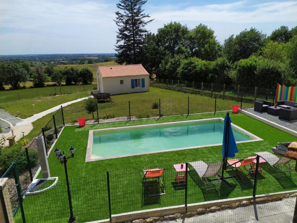 una piscina en un patio con sillas y una casa en Chambre d'hôtes 84 de la Manelière, en La Flocellière