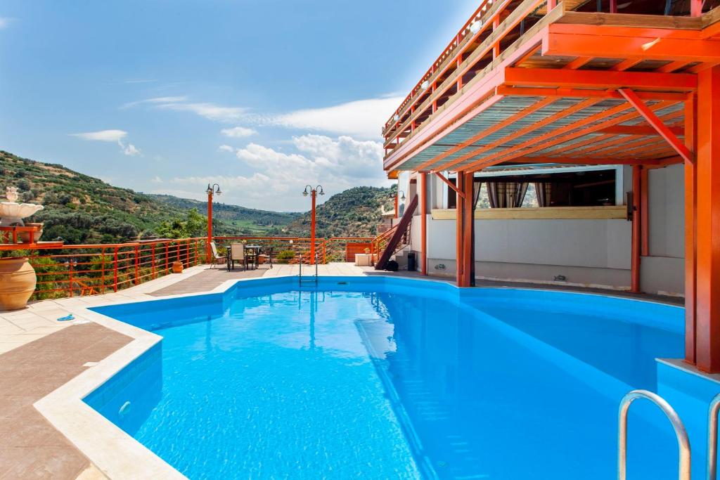 
a large swimming pool with a blue roof at Estate Kares in Tílisos

