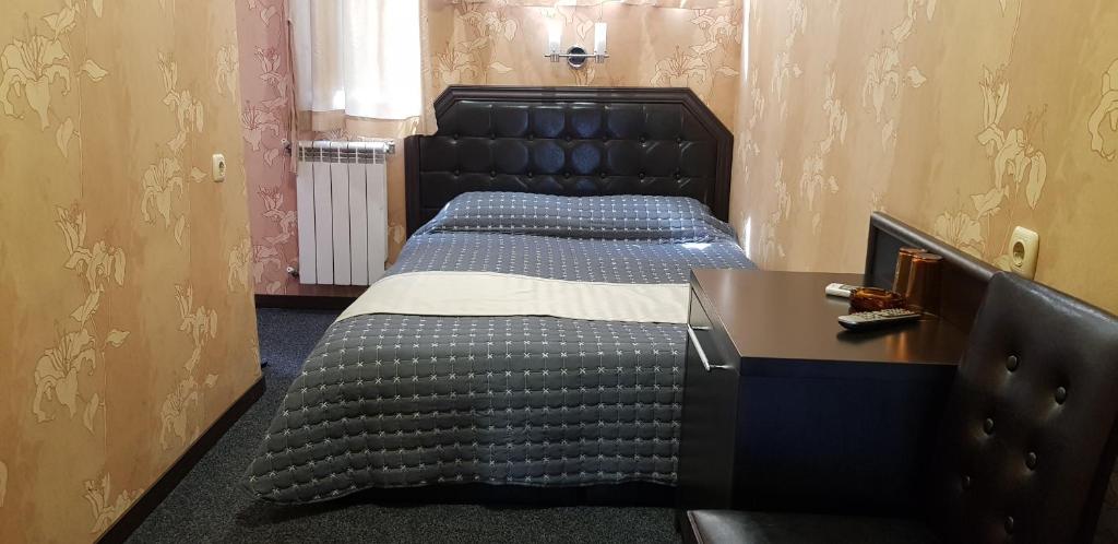 a bedroom with two beds and a desk at Hotel Chamishki in Blagoevgrad