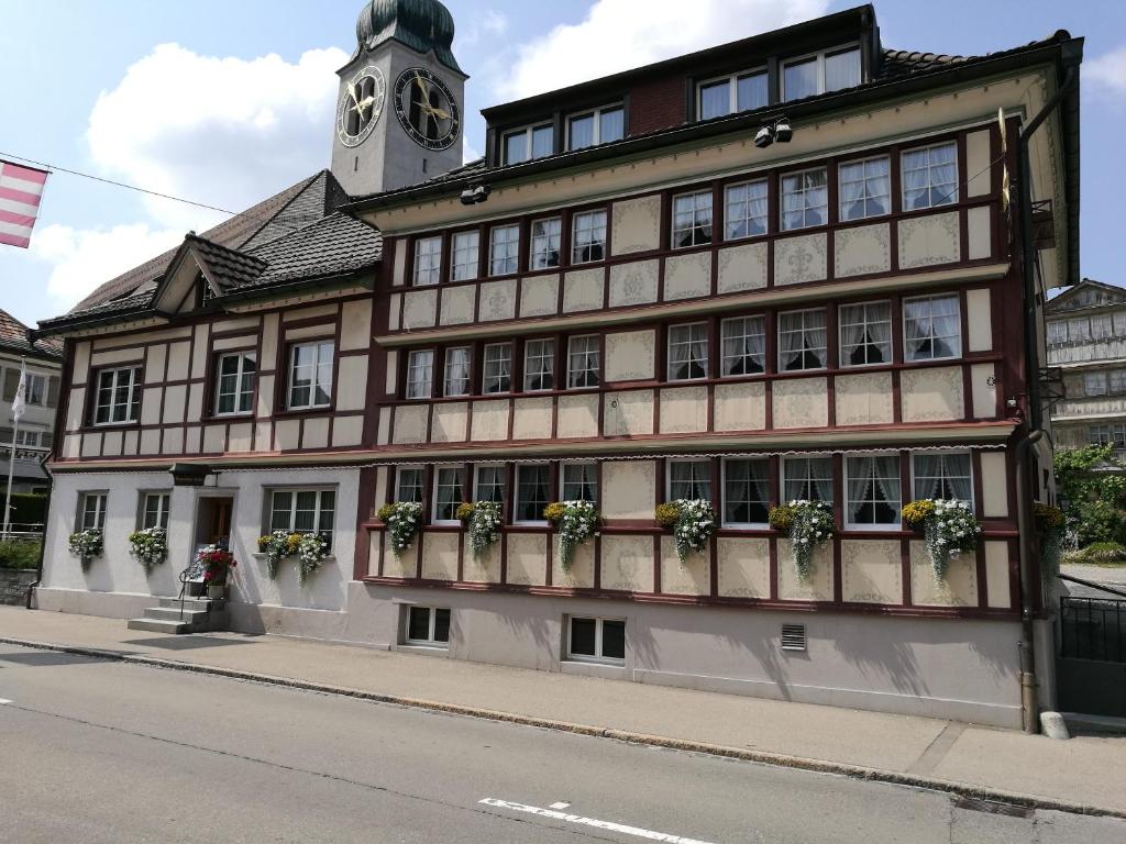 um edifício com uma torre de relógio em cima em Gasthaus Sternen em Degersheim