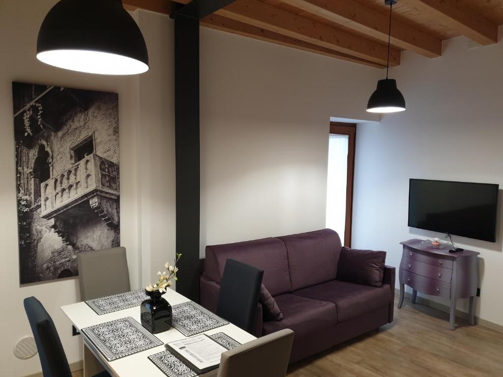 uma sala de estar com um sofá e uma mesa em DIVINA SAN ZENO em Verona