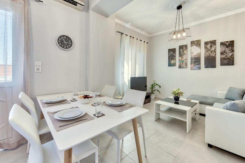 a white dining room and living room with a table and chairs at Angel's Spirit Apartment in Zakynthos Town