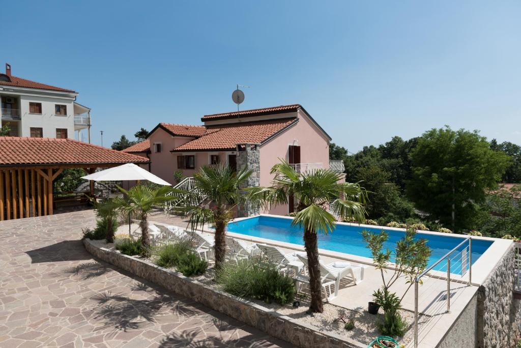 een villa met zwembad en palmbomen bij Castua-apartment with private heated pool in Kastav