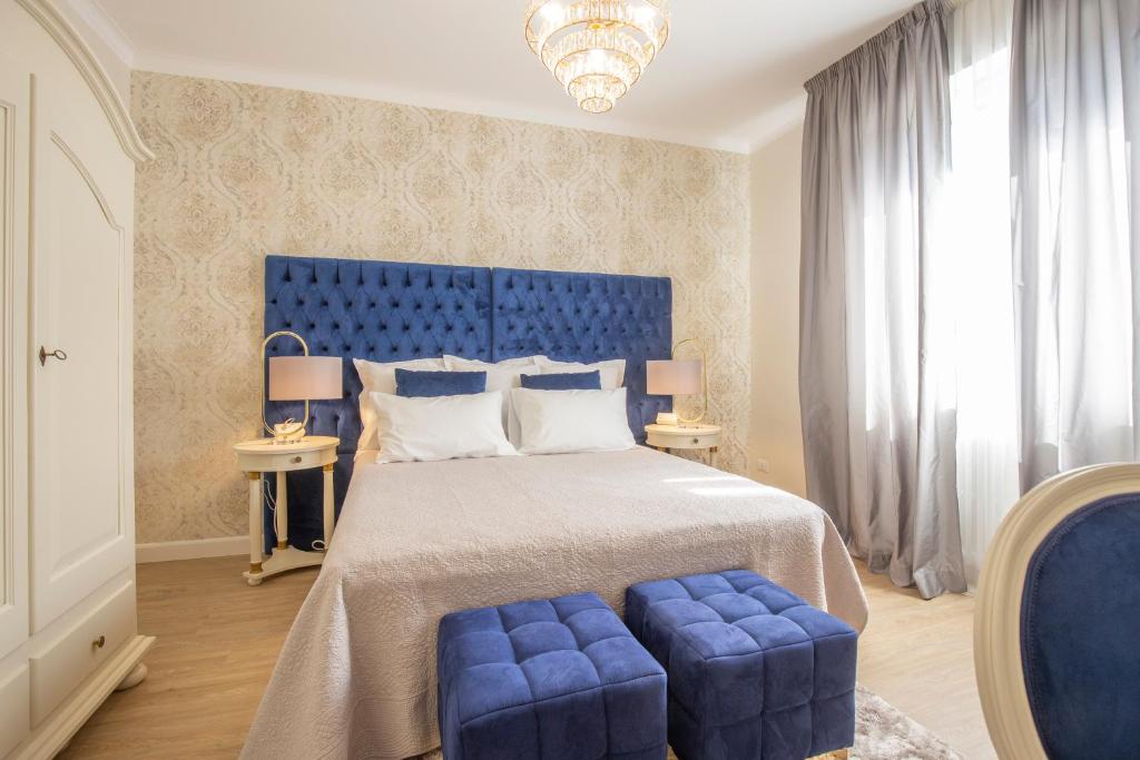 Dormitorio azul con cama grande y cabecero azul en CRYS: Apartments, Holiday, Business, Blu, en Verona