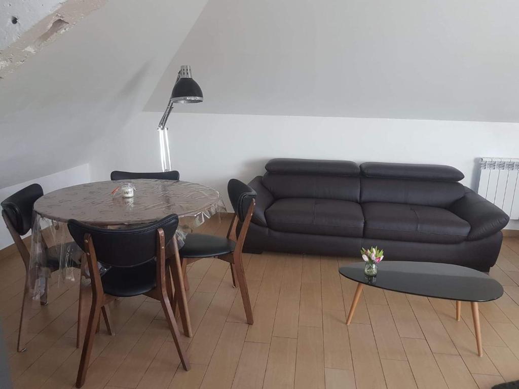 ein Wohnzimmer mit einem Tisch und einem Sofa in der Unterkunft Orléans Appartement 2 chambres avec Parking in Orléans