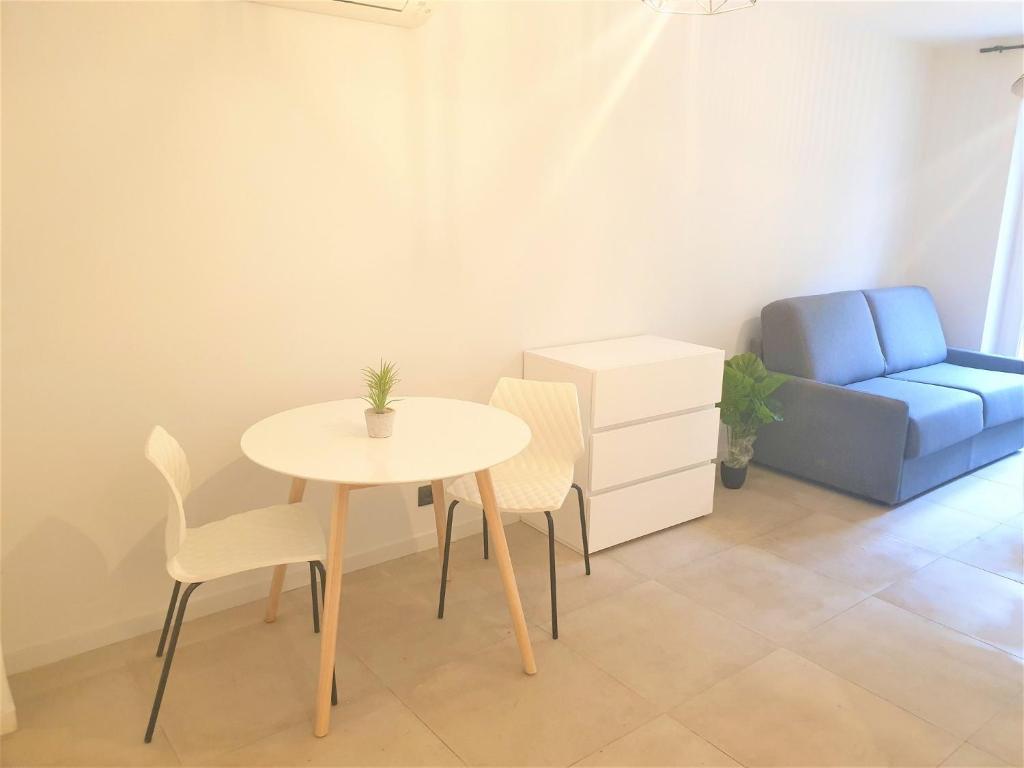 Cette petite chambre comprend une table et une chaise bleue. dans l'établissement ALSACE LORRAINE CENTRE PROCHE MER 101, à Nice