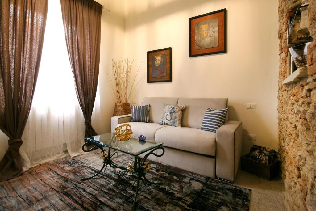 sala de estar con sofá y mesa de cristal en La Piccola Atene, en Pietrasanta
