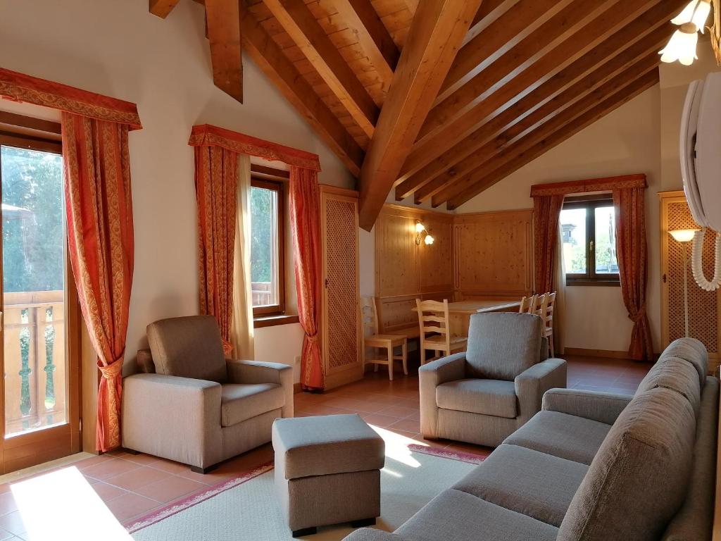sala de estar con sofá, sillas y mesa en Asiago Sporting Lodge en Asiago