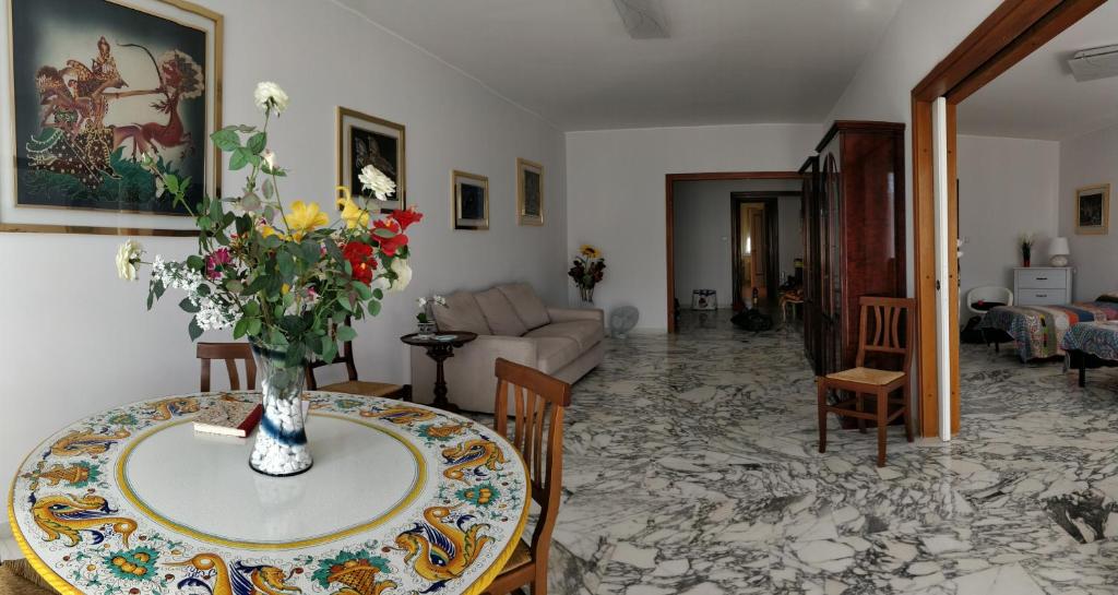 una sala de estar con una mesa con un jarrón de flores. en La Casetta Di Nonna Anna, en Roma