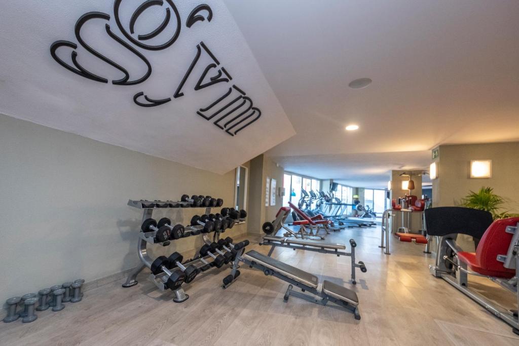 a gym with several treadmills and weights at ARTIEM Audax - Adults Only in Cala Galdana