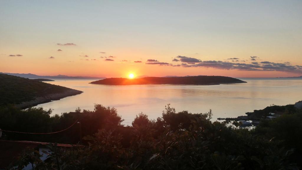 un coucher de soleil sur une étendue d'eau dans l'établissement Sunrise Apartments, à Vis