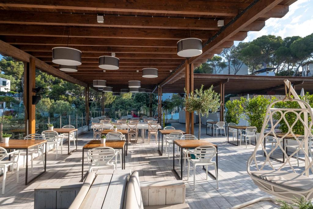 a restaurant with tables and chairs on a patio at ARTIEM Audax - Adults Only in Cala Galdana