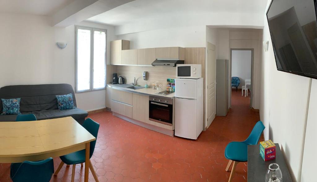 a kitchen and living room with a couch and a table at Appartement l’étoile in Moustiers-Sainte-Marie