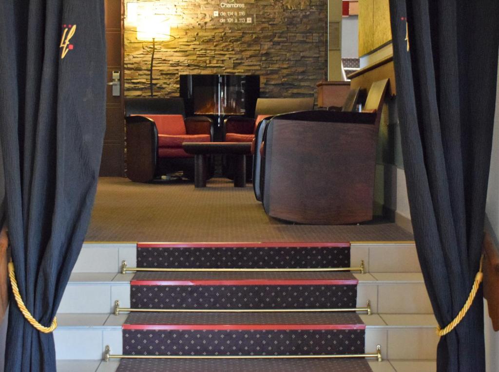 a set of stairs with blue curtains in a waiting room at Logis Hôtel La Fauceille in Perpignan