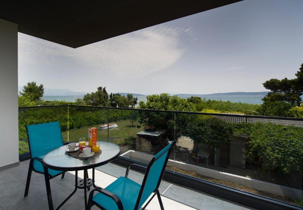 un patio con tavolo e sedie sul balcone. di Vacation On Apartments a Kaštela (Castelli)