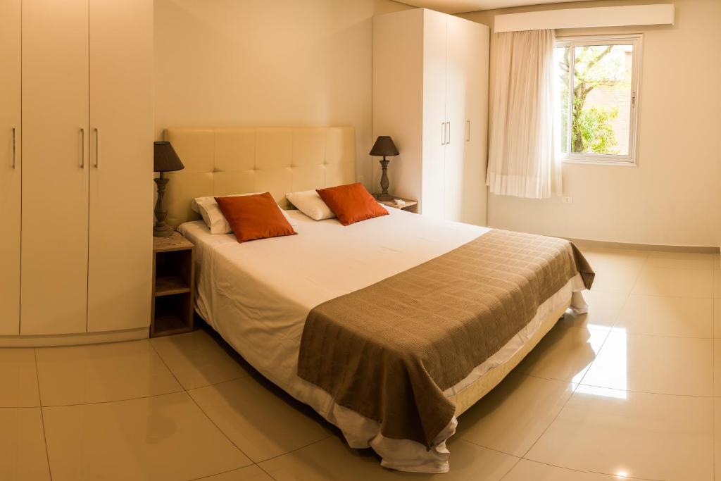 sypialnia z dużym łóżkiem i oknem w obiekcie Realty PY Villa Morra w mieście Asunción