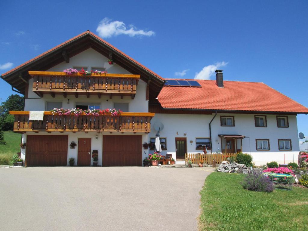 una casa con un balcón con flores. en Ferienwohnung Steible en Isny im Allgäu