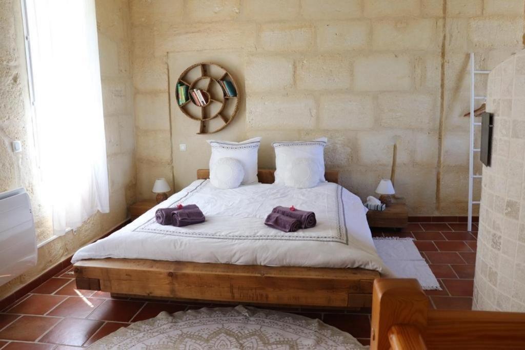 a bedroom with a bed with two bags on it at Mas de l'Hermitage in Moulès