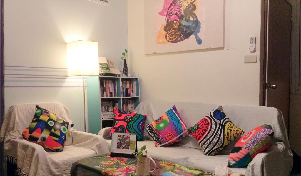 a living room with a couch with pillows on it at La Pace Hostel in Taitung City