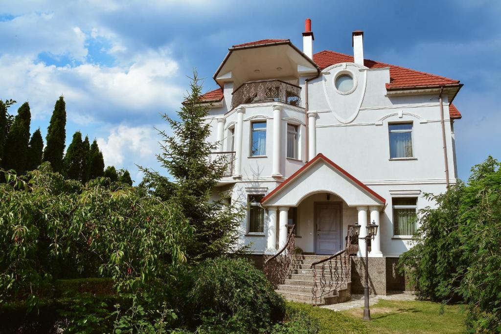 une ancienne maison blanche avec un toit rouge dans l'établissement Bortnichi House, à Kiev