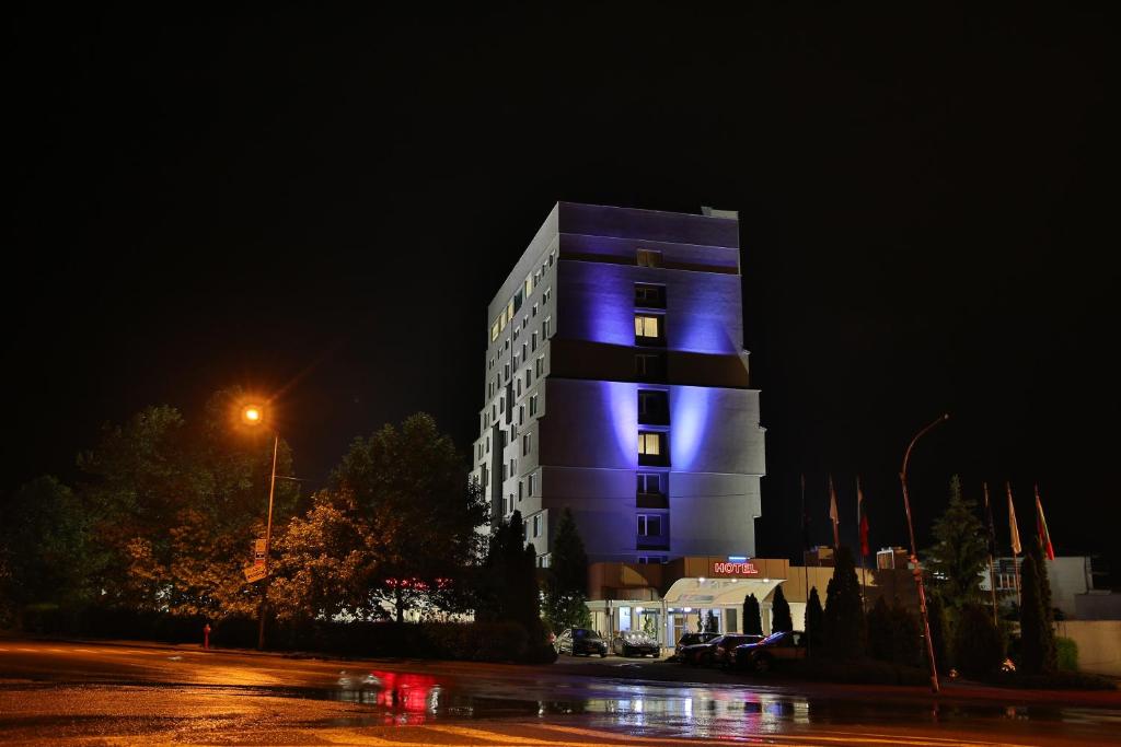 a building with a blue light on it at night at Terra Europe Brontes Hotel in Targovishte