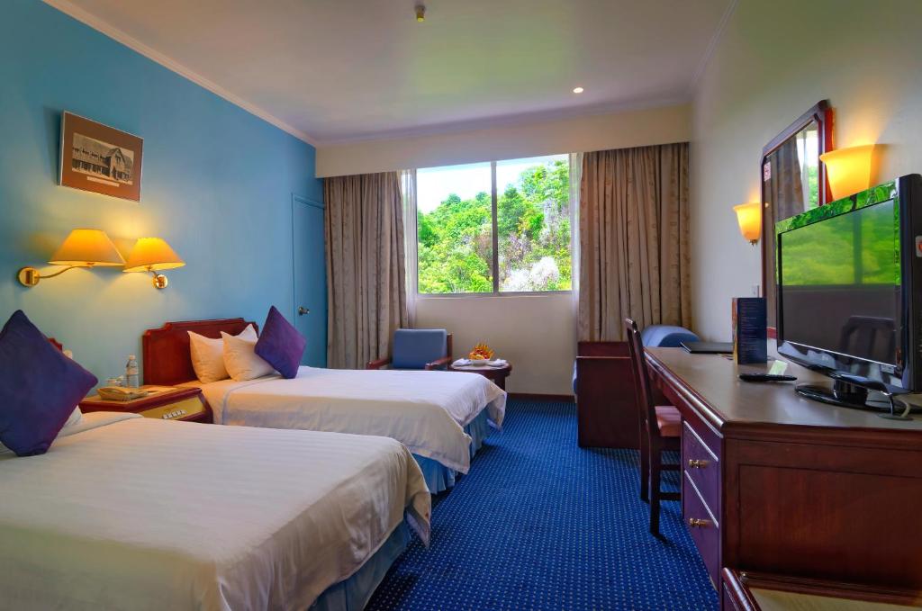 a hotel room with two beds and a flat screen tv at Hotel Shangri-la Kota Kinabalu in Kota Kinabalu