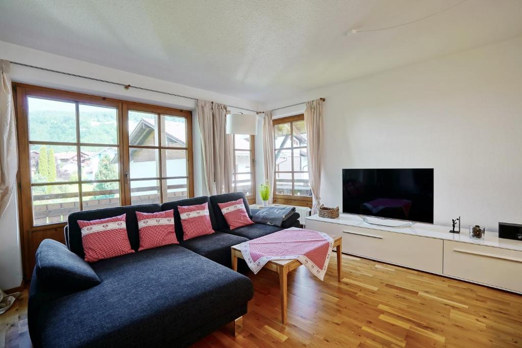 a living room with a blue couch and a tv at Rettenberger Murmele in Rettenberg