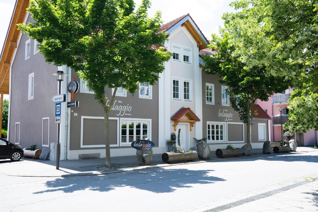 ein Gebäude mit einem Baum davor in der Unterkunft Vila Belaggio in Plattling