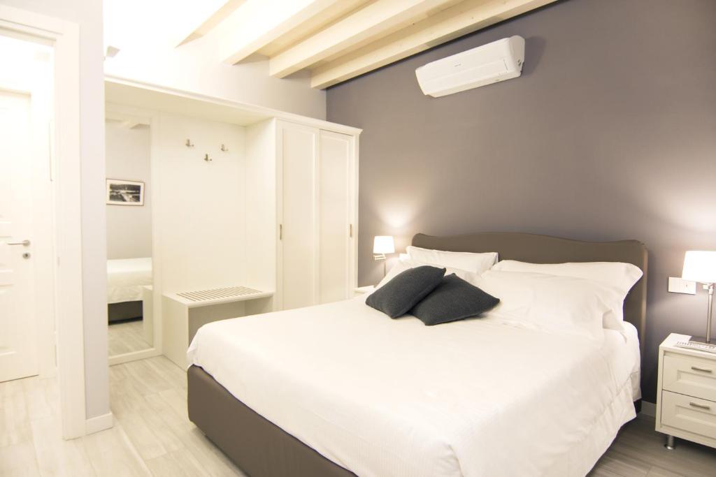 1 dormitorio con 1 cama blanca grande y 2 almohadas en LA QUADRA SUITES - Central Apartments in Iseo, en Iseo