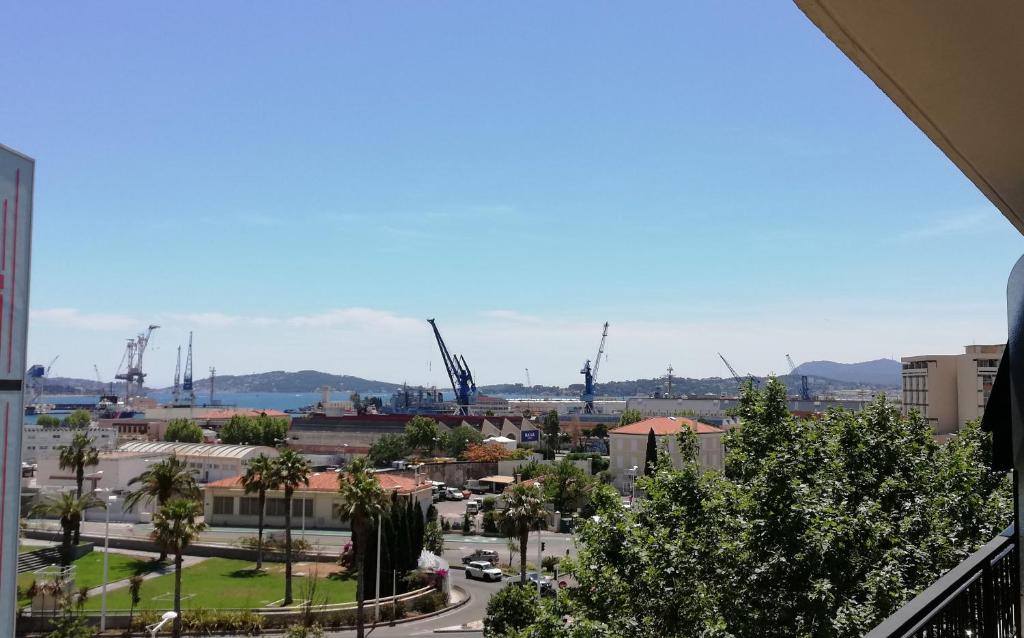 une vue sur une ville avec des grues au loin dans l'établissement Le Grand Appart' Toulon, à Toulon