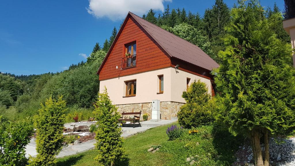 una casa con techo rojo en un bosque en Drevenica pod Horou en Vyšná Korňa