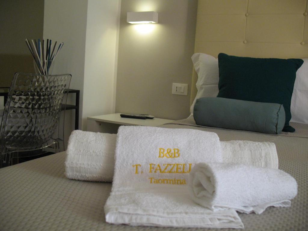 Un dormitorio con una cama con toallas. en Bed&Bed Tommaso Fazzello only rooms, en Taormina