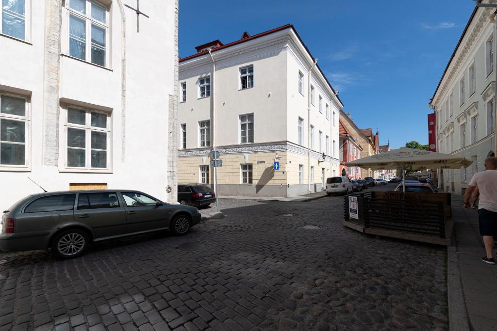 a car parked on a brick street next to buildings at Apartment in Old Town Lai street in Tallinn