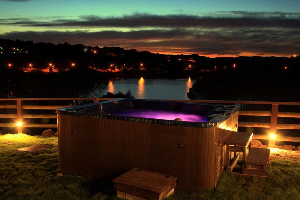 a hot tub in the grass with a view of a river at LAS CABAÑAS DEL LAGO in Córdoba