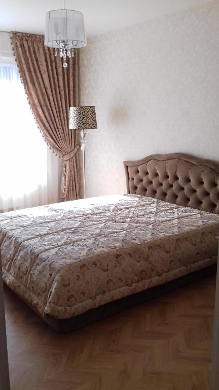 ein großes Bett in einem Schlafzimmer mit Fenster in der Unterkunft Gandrališkės apartamentai in Klaipėda