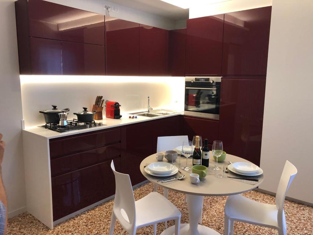 a kitchen with a table and chairs and a kitchen with purple cabinets at Le Piazzette Schio in Schio